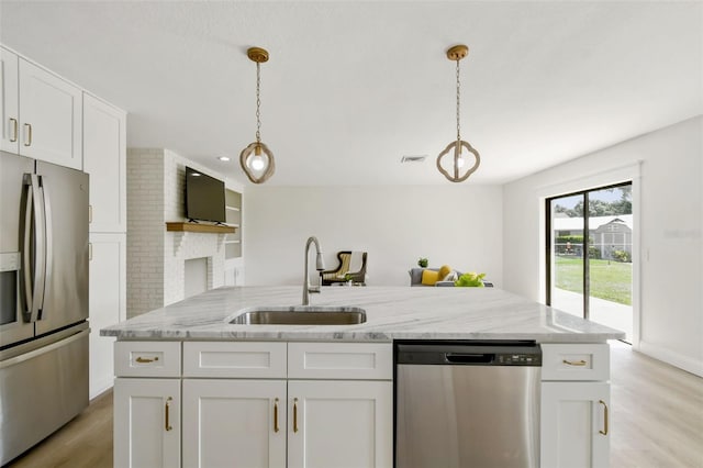 2004 Varner Cir, Winter Haven, FL 33884 - kitchen featuring stainless steel appliances, white cabinets, light wood-type flooring, light stone countertops, and decorative light fixtures