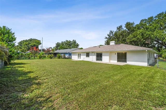 2004 Varner Cir, Winter Haven, FL 33884 - rear view of house featuring stucco siding, a fenced backyard, a chimney, and a patio area