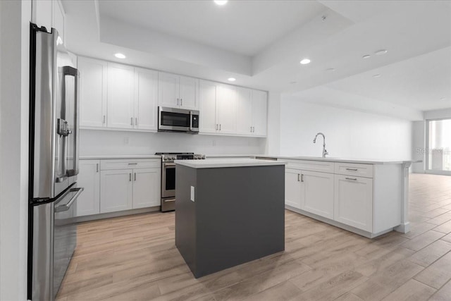 125 Island Way Unit 403, Clearwater, FL 33767 - kitchen with stainless steel appliances, recessed lighting, a kitchen island, light wood finished floors, and light countertops