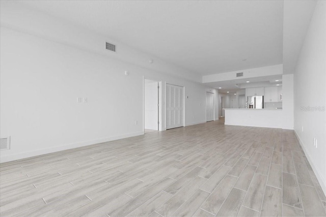 125 Island Way Unit 403, Clearwater, FL 33767 - unfurnished living room featuring light wood finished floors and recessed lighting
