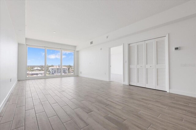 125 Island Way Unit 403, Clearwater, FL 33767 - unfurnished living room with wood finished floors and baseboards
