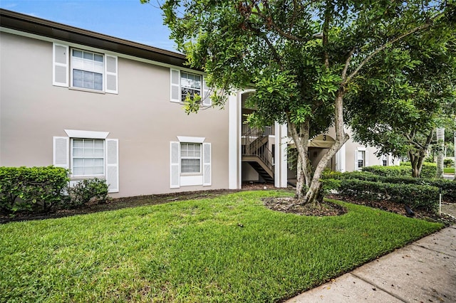 5265 E Bay Dr Unit 313, Clearwater, FL 33764 - view of front of property with stucco siding, a front lawn, and stairway