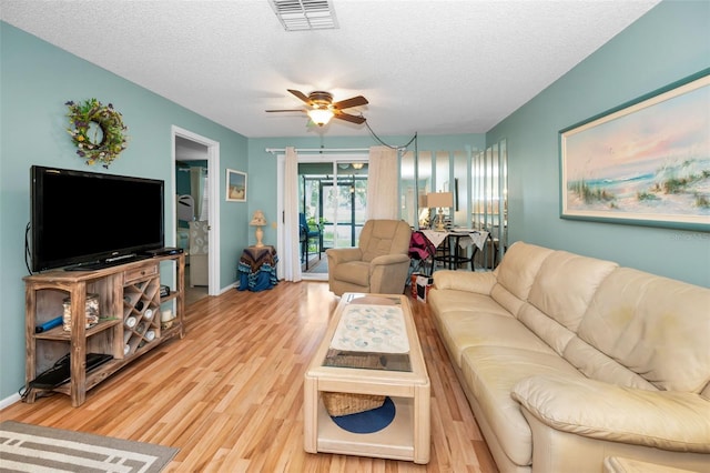 5265 E Bay Dr Unit 313, Clearwater, FL 33764 - living area featuring a textured ceiling, a ceiling fan, and light wood-type flooring