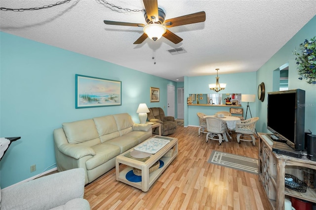 5265 E Bay Dr Unit 313, Clearwater, FL 33764 - living room with a chandelier, wood finished floors, a ceiling fan, and a textured ceiling