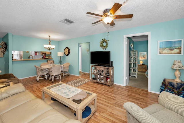 5265 E Bay Dr Unit 313, Clearwater, FL 33764 - living area with a chandelier, ceiling fan, wood finished floors, and a textured ceiling