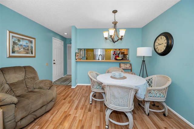 5265 E Bay Dr Unit 313, Clearwater, FL 33764 - dining room featuring a chandelier, wood finished floors, and a textured ceiling
