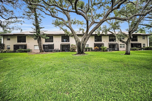 5265 E Bay Dr Unit 313, Clearwater, FL 33764 - rear view of property featuring stucco siding and a yard