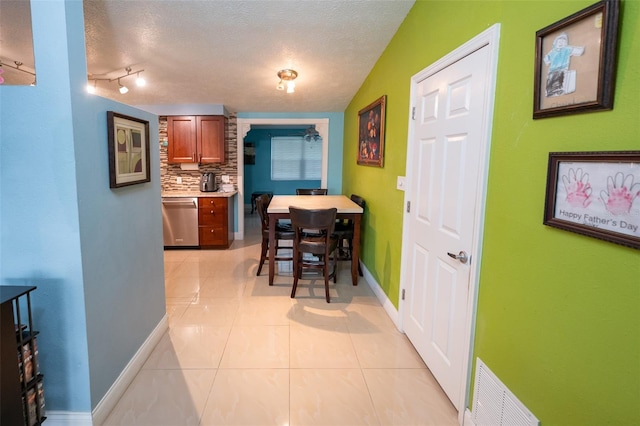 4239 Cardoon Dr, New Port Richey, FL 34653 - dining space featuring light tile patterned flooring, a textured ceiling, and track lighting
