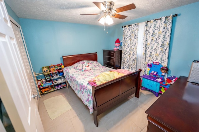4239 Cardoon Dr, New Port Richey, FL 34653 - bedroom featuring a textured ceiling, a ceiling fan, and tile patterned flooring