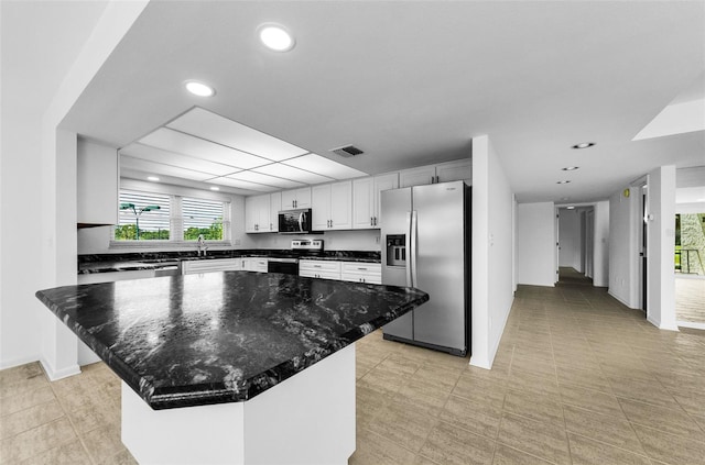 3021 Countryside Blvd Unit 28A, Clearwater, FL 33761 - kitchen featuring appliances with stainless steel finishes, plenty of natural light, a center island, recessed lighting, and white cabinetry