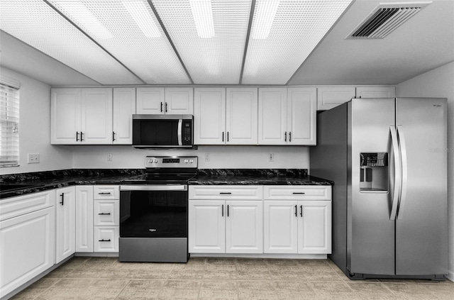 3021 Countryside Blvd Unit 28A, Clearwater, FL 33761 - kitchen featuring stainless steel appliances, white cabinetry, and dark stone counters