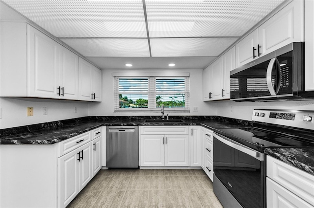 3021 Countryside Blvd Unit 28A, Clearwater, FL 33761 - kitchen featuring appliances with stainless steel finishes, white cabinets, dark stone counters, light tile patterned floors, and recessed lighting