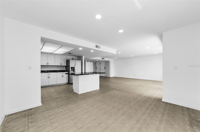 3021 Countryside Blvd Unit 28A, Clearwater, FL 33761 - kitchen featuring white cabinets, recessed lighting, dark countertops, open floor plan, and stainless steel fridge with ice dispenser