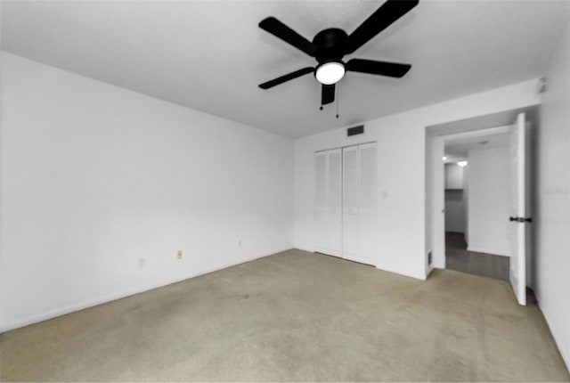 3021 Countryside Blvd Unit 28A, Clearwater, FL 33761 - unfurnished bedroom featuring light carpet, a closet, and ceiling fan