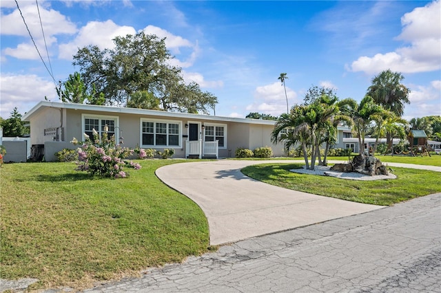 327 Sunny Ln, Belleair, FL 33756 - single story home with stucco siding, curved driveway, and a front lawn