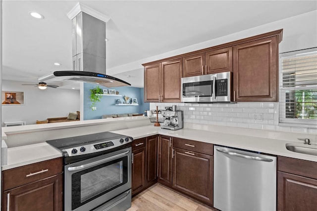 327 Sunny Ln, Belleair, FL 33756 - kitchen featuring stainless steel appliances, light countertops, a peninsula, and decorative backsplash