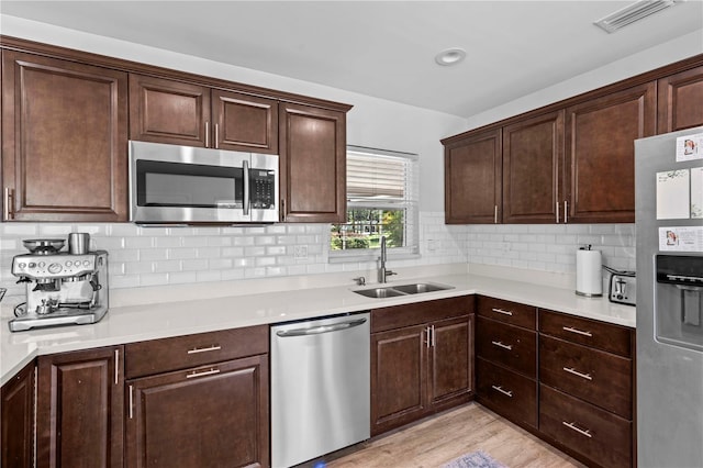 327 Sunny Ln, Belleair, FL 33756 - kitchen featuring appliances with stainless steel finishes, dark brown cabinets, light countertops, and decorative backsplash