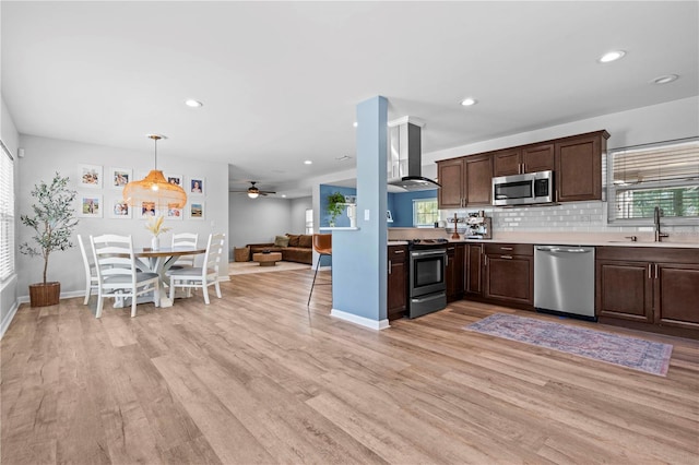 327 Sunny Ln, Belleair, FL 33756 - kitchen with appliances with stainless steel finishes, extractor fan, dark brown cabinetry, light wood-style floors, and light countertops