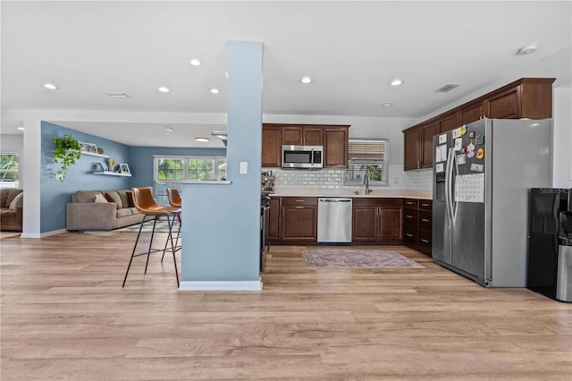 327 Sunny Ln, Belleair, FL 33756 - kitchen with stainless steel appliances, open floor plan, light wood-style floors, healthy amount of natural light, and recessed lighting