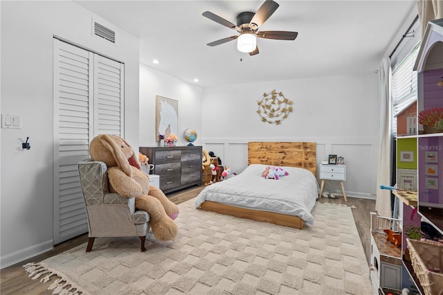 327 Sunny Ln, Belleair, FL 33756 - bedroom featuring a wainscoted wall, a ceiling fan, recessed lighting, wood finished floors, and a decorative wall