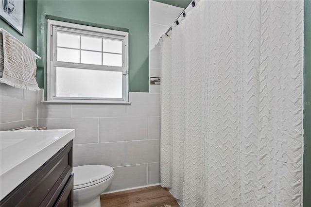 327 Sunny Ln, Belleair, FL 33756 - bathroom featuring tile walls, wood finished floors, vanity, a shower with curtain, and wainscoting