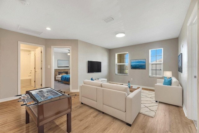1192 Multiflora Loop, Lutz, FL 33558 - living room featuring light wood-type flooring and a lit fireplace