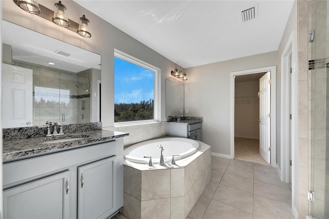 1192 Multiflora Loop, Lutz, FL 33558 - bathroom with a shower stall, two vanities, tile patterned flooring, a garden tub, and a walk in closet