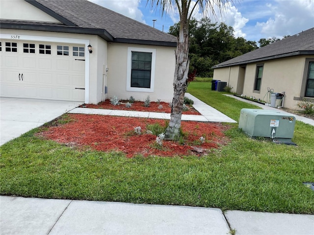 5578 Maggiore Blvd, Lakeland, FL 33805 - view of front of home featuring roof with shingles, a front lawn, stucco siding, an attached garage, and concrete driveway
