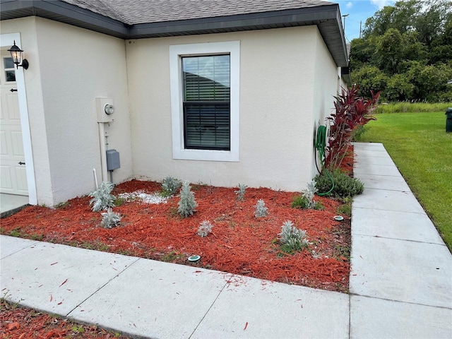 5578 Maggiore Blvd, Lakeland, FL 33805 - view of side of property featuring a shingled roof, stucco siding, and a yard
