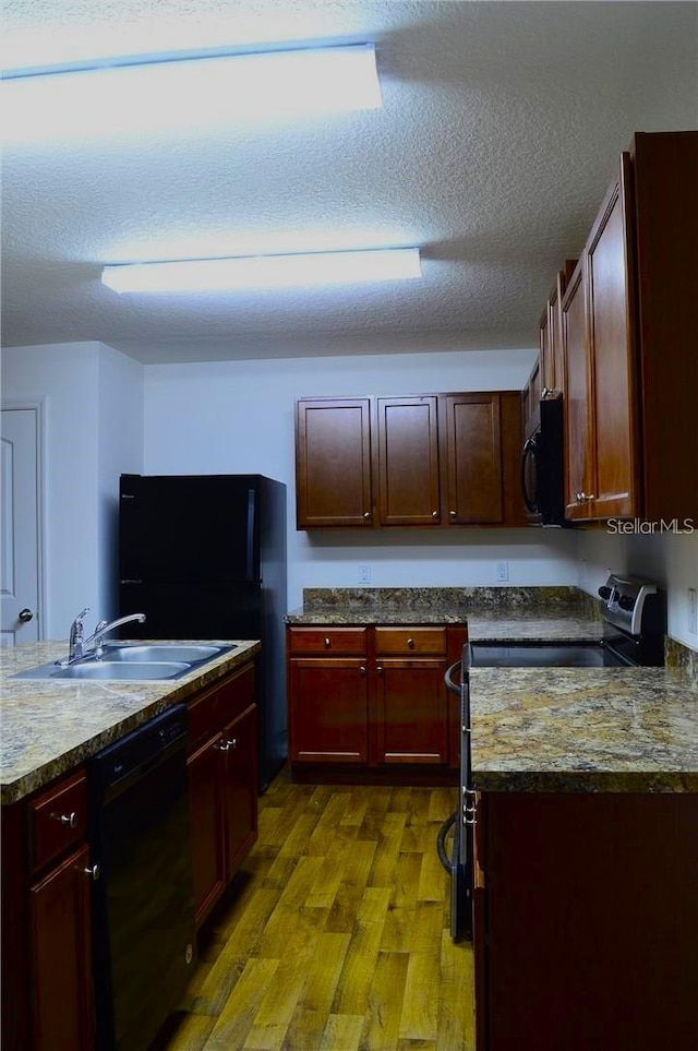 5578 Maggiore Blvd, Lakeland, FL 33805 - kitchen with black appliances, dark wood finished floors, reddish brown cabinets, and a textured ceiling