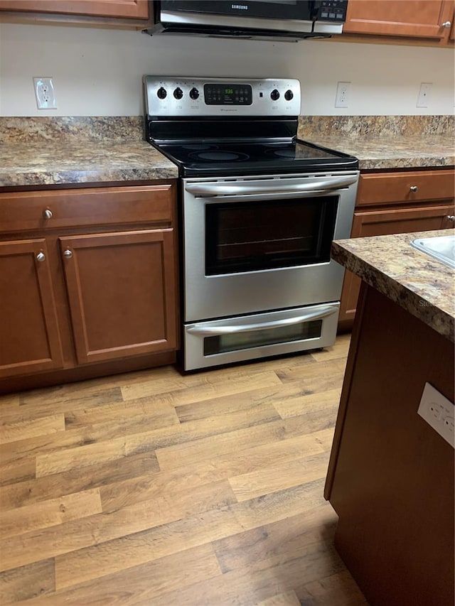 5578 Maggiore Blvd, Lakeland, FL 33805 - kitchen featuring stainless steel electric stove, black microwave, and light wood finished floors