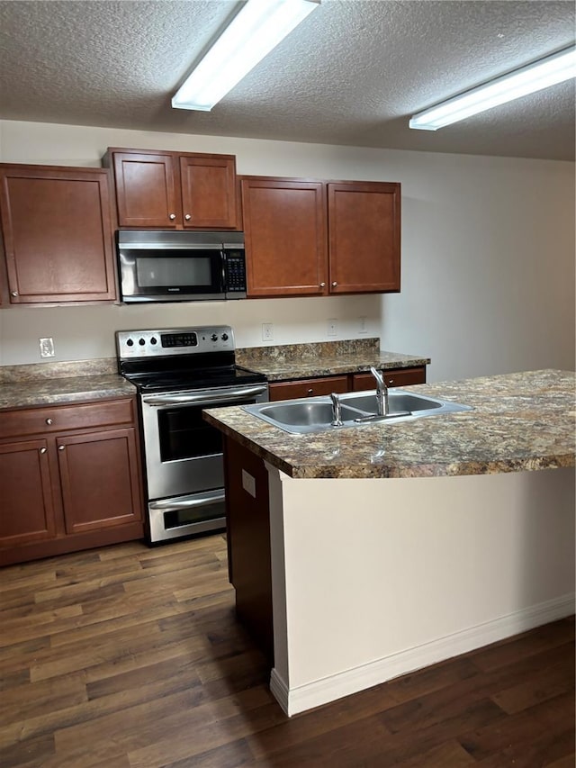 5578 Maggiore Blvd, Lakeland, FL 33805 - kitchen with appliances with stainless steel finishes, dark wood-style floors, dark countertops, and a textured ceiling