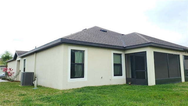 5578 Maggiore Blvd, Lakeland, FL 33805 - rear view of property with roof with shingles, stucco siding, a sunroom, and a lawn