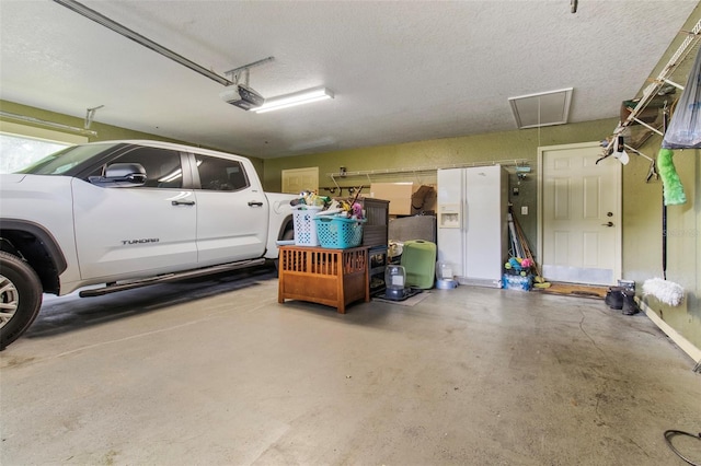 70 Arthur Ln, Winter Haven, FL 33880 - garage with a garage door opener and white fridge with ice dispenser