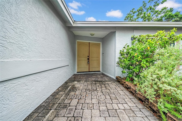 12402 84th Way, Largo, FL 33773 - doorway to property featuring stucco siding