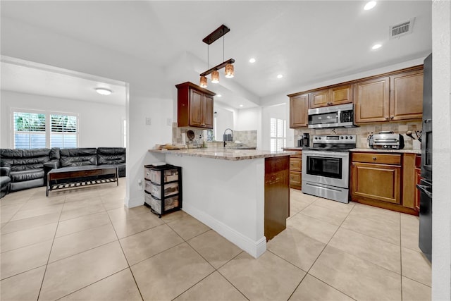 12402 84th Way, Largo, FL 33773 - kitchen with stainless steel appliances, decorative backsplash, a peninsula, open floor plan, and recessed lighting