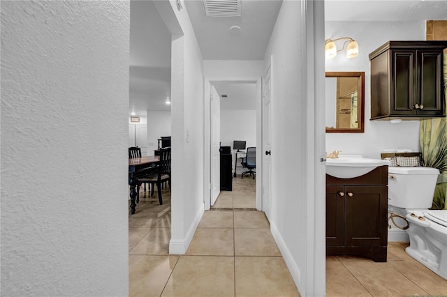 12402 84th Way, Largo, FL 33773 - corridor with light tile patterned flooring, a textured wall, and a desk