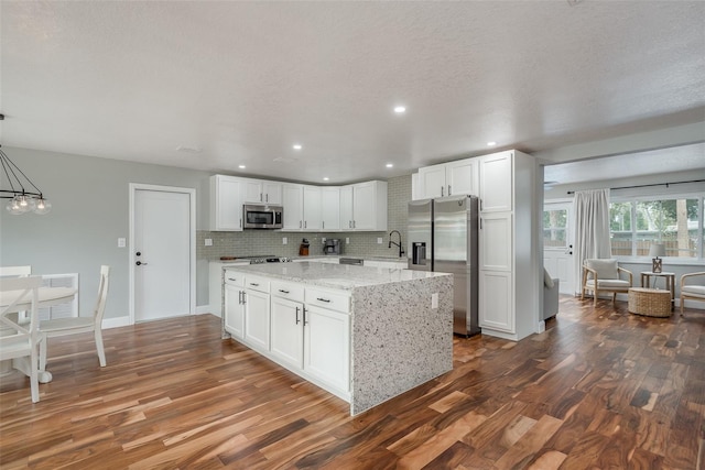1762 Bayshore Blvd, Dunedin, FL 34698 - kitchen with appliances with stainless steel finishes, dark wood-type flooring, white cabinetry, light stone counters, and recessed lighting