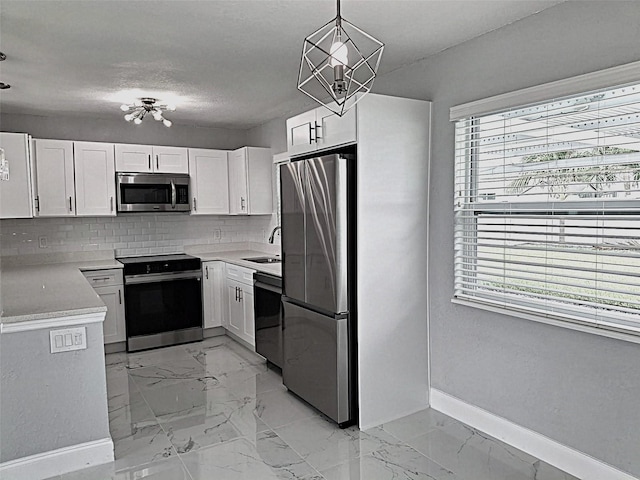 450 82nd Ave, St Pete Beach, FL 33706 - kitchen with stainless steel appliances, decorative backsplash, plenty of natural light, and light marble finish flooring
