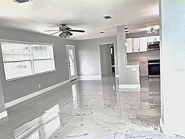 450 82nd Ave, St Pete Beach, FL 33706 - kitchen with stainless steel microwave, range with electric stovetop, ceiling fan, white cabinets, and light marble finish floors