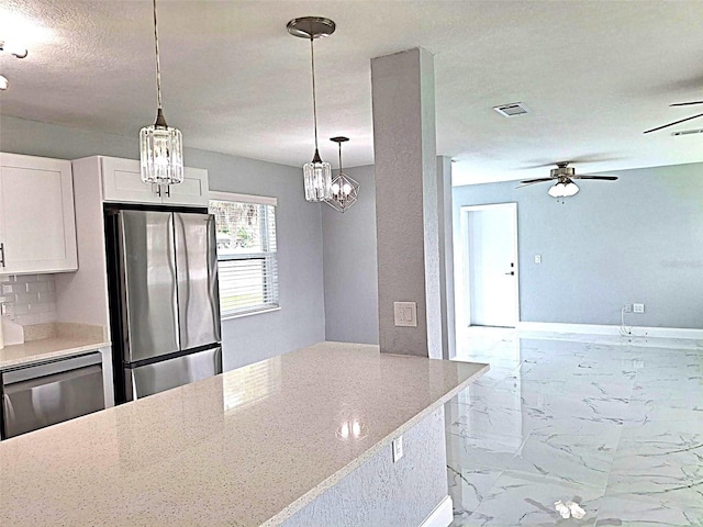 450 82nd Ave, St Pete Beach, FL 33706 - kitchen featuring appliances with stainless steel finishes, a ceiling fan, marble look tile flooring, white cabinetry, and light stone counters