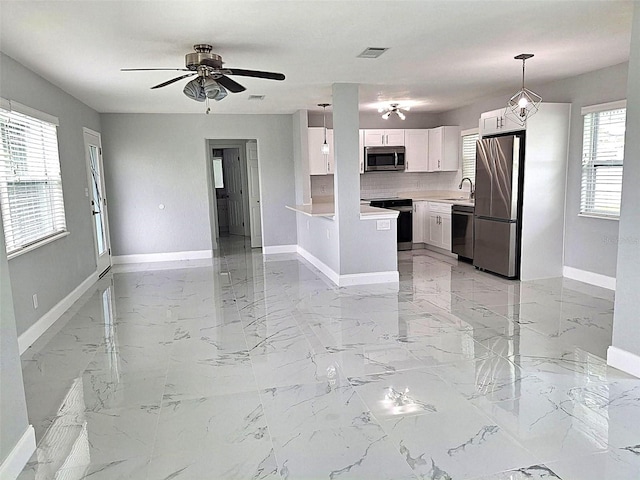 450 82nd Ave, St Pete Beach, FL 33706 - kitchen with appliances with stainless steel finishes, white cabinets, light countertops, ceiling fan, and open floor plan