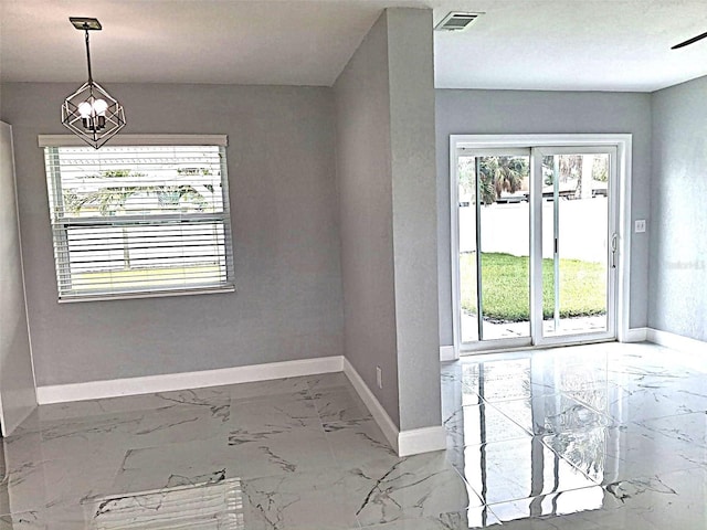 450 82nd Ave, St Pete Beach, FL 33706 - unfurnished dining area with marble finish flooring and a chandelier