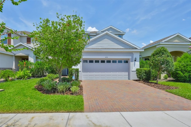 6215 Voyagers Pl, Apollo Beach, FL 33572 - view of front of house with an attached garage, decorative driveway, a front yard, and stucco siding