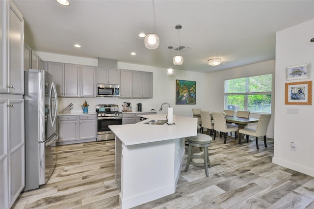 6215 Voyagers Pl, Apollo Beach, FL 33572 - kitchen featuring stainless steel appliances, gray cabinets, light wood finished floors, and recessed lighting