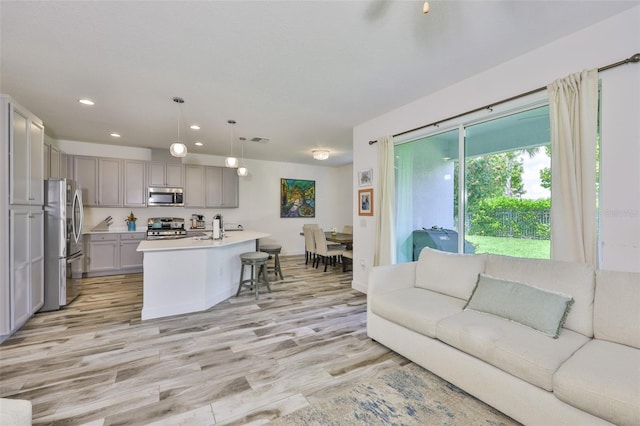 6215 Voyagers Pl, Apollo Beach, FL 33572 - kitchen featuring stainless steel appliances, gray cabinetry, recessed lighting, light countertops, and light wood-type flooring