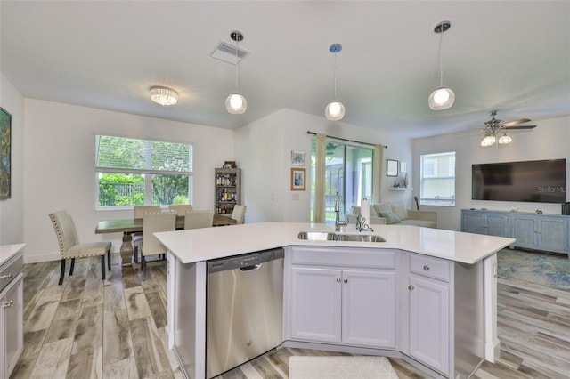 6215 Voyagers Pl, Apollo Beach, FL 33572 - kitchen with stainless steel dishwasher, open floor plan, light countertops, and light wood-style floors