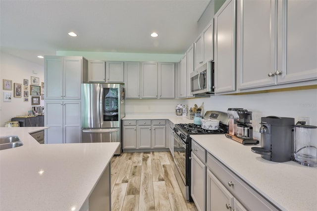 6215 Voyagers Pl, Apollo Beach, FL 33572 - kitchen with stainless steel appliances, light countertops, light wood-style floors, and recessed lighting