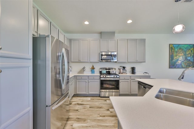 6215 Voyagers Pl, Apollo Beach, FL 33572 - kitchen featuring stainless steel appliances, light countertops, recessed lighting, light wood-style floors, and decorative light fixtures