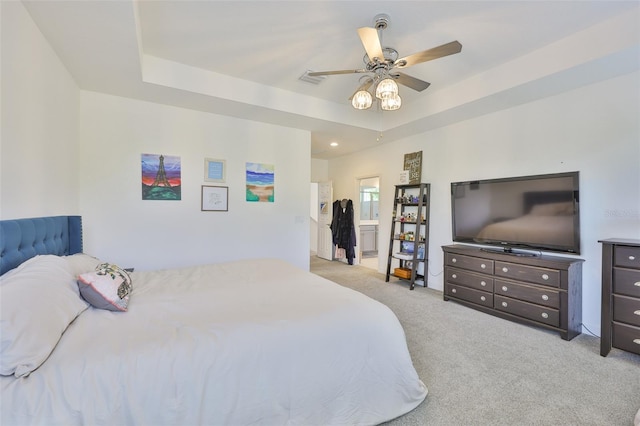 6215 Voyagers Pl, Apollo Beach, FL 33572 - bedroom with light colored carpet, a tray ceiling, ceiling fan, and connected bathroom